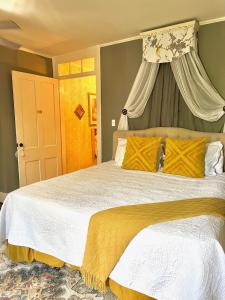 纳奇兹The Beaumont House Natchez的卧室配有一张带黄色枕头的大型白色床。