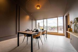 蒙斯Luxury Penthouse & Terrace - Mons City Center的一间带桌椅和大窗户的用餐室