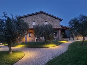 古比奥Agriturismo Caiferri con spa的前面有树木的石头房子