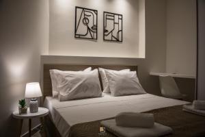海若克利欧Uni Island - Old Town Suites的一间卧室配有带白色床单和枕头的床。
