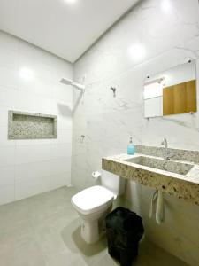 帕劳阿佩巴斯Hostel Flor de Carajás的白色的浴室设有卫生间和水槽。