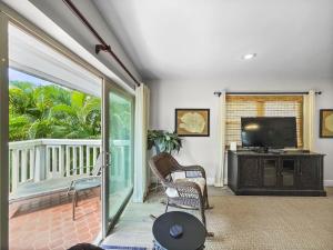 西耶斯塔岛Spacious Updated Condo Just 2 Blocks to Siesta Key Beach的一间带电视和滑动玻璃门的客厅