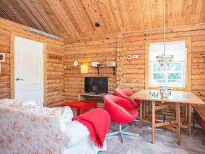 HovborgHoliday home Hovborg VII的小木屋客厅配有桌子和红色椅子