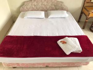 不拉士打宜Hotel Miranda at Desa Wisata Berastagi的床上有红白毯子