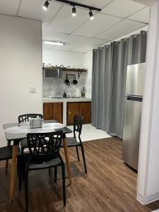 巴拿马城SERENADE Lodging Rooms的厨房配有桌椅和冰箱。