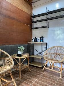 LhongaSaho Coffee & Rooms的一间设有两把椅子、一张桌子和一个架子的房间
