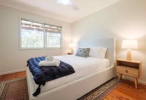 蒙恩维优Yarramie的一间卧室配有一张带蓝色毯子的床和窗户。
