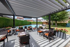 热拉梅豪华温泉酒店的一个带桌椅的庭院和一个游泳池