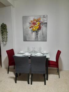 马萨尔福恩Gozo Marsalforn的餐桌、椅子和墙上的绘画