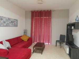 马萨尔福恩Gozo Marsalforn的客厅里红色的沙发,配有红色窗帘