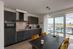 圣安娜兰Appartement Vista Maris, Havenweg 8-2, Sint Annaland的一个带桌子的厨房和一个美景厨房