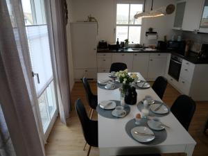 齐罗neben Wismar FH"FaJuKa" Strandnah mit Wallbox的厨房配有白色桌子、椅子和鲜花