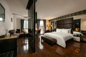 河内La Nueva Boutique Hotel Hanoi & Spa的一间卧室配有一张大床和一张沙发