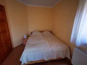 扎马迪Vécsey nyaralóház的一间小卧室,配有白色的床和窗户