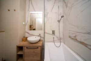 格但斯克Maya's Flats & Resorts 30 - 3 rooms flat in Garden Gate Gdansk的浴室配有水槽、淋浴和浴缸。