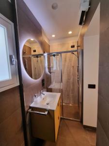 那不勒斯Archihouse Suites的浴室配有盥洗盆和带镜子的淋浴