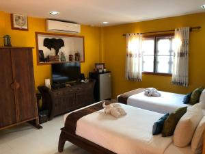 琅勃拉邦On The Mekong Resort的一间卧室配有两张床和一台平面电视