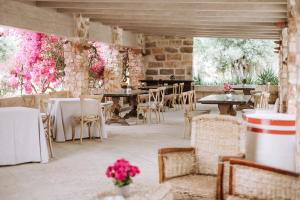 莫诺波利Masseria Torrepietra的一间带桌椅和粉红色鲜花的餐厅