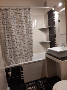 霍德梅泽瓦沙海伊Sunnyrise Apartman的浴室配有淋浴帘和盥洗盆。