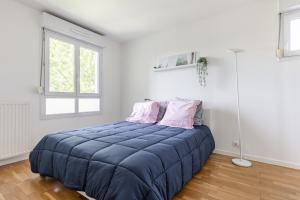 楠泰尔Design 3 bedrooms appartment, near Champs Elysees的一间卧室配有一张大蓝色的床和两个粉红色枕头