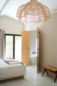拉西约塔l'Amarantine的一间卧室配有一张床和一个吊灯