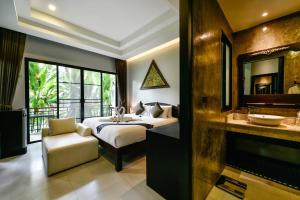 普吉镇Coco Paradiso Phuket SHA的一间卧室配有一张床,浴室设有水槽