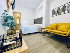 奇皮奥纳圣容旅游公寓的客厅配有黄色的沙发和床。