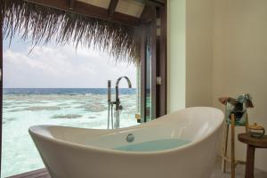 丹格迪Drift Thelu Veliga Retreat的带浴缸的浴室,享有海景。