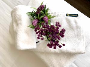 清迈Ç精品舒适酒店 的白色毛巾上一束紫色花