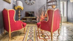 马丁纳弗兰卡La chiocciola grigia的客厅配有2把红色椅子和电视