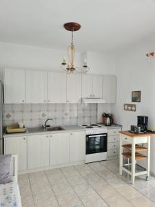 奥弗里安Sophies Sea View Apartment Touzla的厨房配有白色橱柜和吊灯。