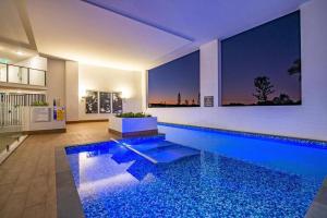 巴迪纳Resort Style 3 Bed 2 Bath, 200m from Beach的一座大型游泳池,位于带房子的房间里