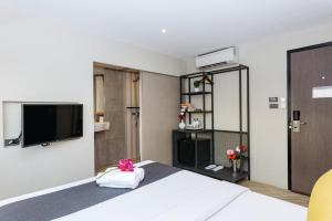 曼谷Lucky House Khaosan的配有一张床和一台平面电视的酒店客房