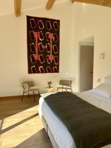帕尔兹哈克Domaine de Panery的卧室配有一张床,墙上挂有绘画作品