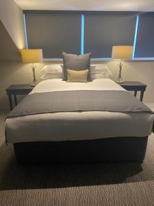 巴克斯顿老霍酒店的一张大床,位于带两盏灯的房间