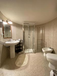 雷阿尔蒙特Villa Venere Apartment的带淋浴、盥洗盆和卫生间的浴室