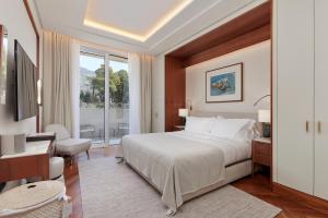 蒂瓦特Porto Montenegro Residences的配有一张床、一张书桌和一扇窗户的酒店客房
