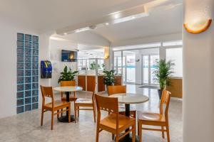圣安东尼奥Aparthotel Vibra del Mar - Adults only的一间带2张桌子和椅子的用餐室
