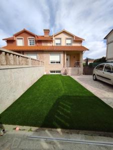 坎加斯德穆拉索"A Marosa", bonito chalet dúplex的前面有绿色草坪的房子