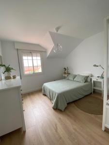 坎加斯德穆拉索"A Marosa", bonito chalet dúplex的白色的卧室设有床和窗户