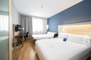 巴塞罗那Holiday Inn Express Barcelona City 22@, an IHG Hotel的酒店客房设有一张白色大床和一张书桌