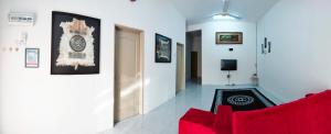 斯里伊斯兰德WAFID HOMESTAY SERI ISKANDAR的客厅配有红色的沙发和墙上的时钟