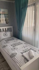 辛尼莫雷特La Veranda Sinemorets的卧室配有白色床和蓝色窗帘