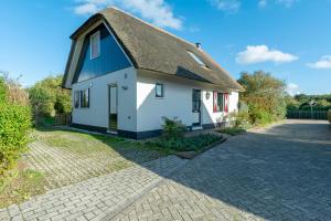 卡兰茨奥赫Buitenplaats 89 Callantsoog的白色和蓝色的房屋,拥有茅草屋顶
