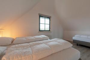 卡兰茨奥赫Buitenplaats 89 Callantsoog的白色的客房设有两张床和窗户。