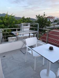 卡萨米尔Villa Egli Ksamil的阳台的白色椅子和桌子