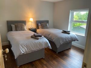 Rivers TownRedhills Mohill的一间卧室设有两张床和窗户。