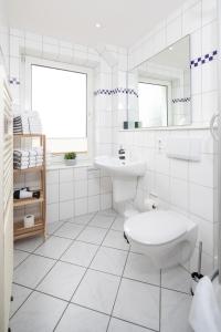 诺德奈Lüttje Schmiede的白色的浴室设有卫生间和水槽。