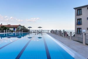 卡拉古诺内Hotel Brancamaria的一座游泳池毗邻一座建筑和大海