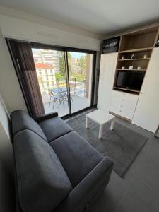 芒通Appartement tout équipé centre ville Menton的带沙发和大窗户的客厅